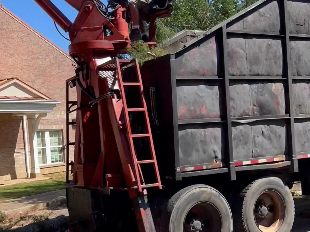The All About Trees grapple loader truck loading brush on a job
