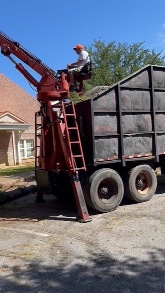 The All About Trees grapple loader truck loading brush on a job