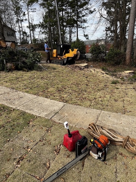 A cleared yard with the tracked machine and cutting gear on site